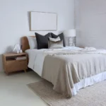 A bright bedroom with a wooden bed where the Eliza, a set of 4 bed cushions is displayed.