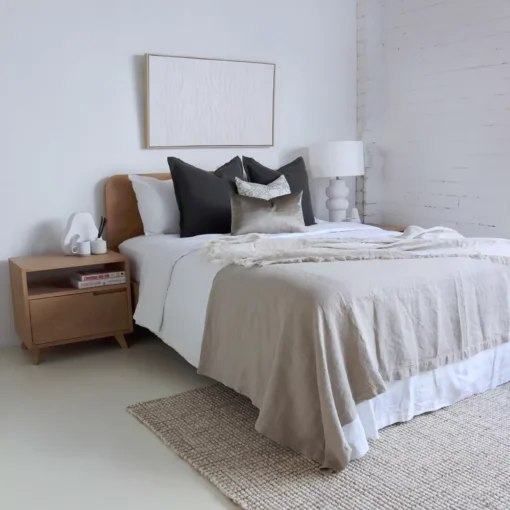 A bright bedroom with a wooden bed where the Eliza, a set of 4 bed cushions is displayed.