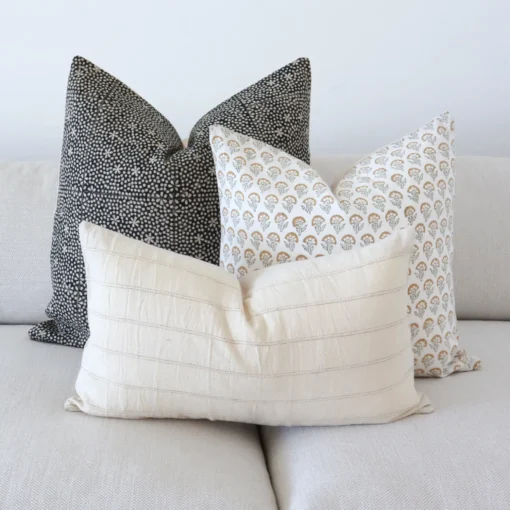The Essa designer couch cushions are beautifully arranged on a grey sofa.