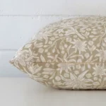 A floral cushion cover is laid flat. This angle shows the side of the linen fabric and its rectangle shape.