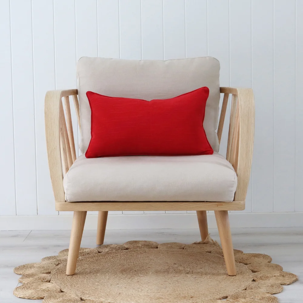 A front on view of a chair with a red cushion on it.