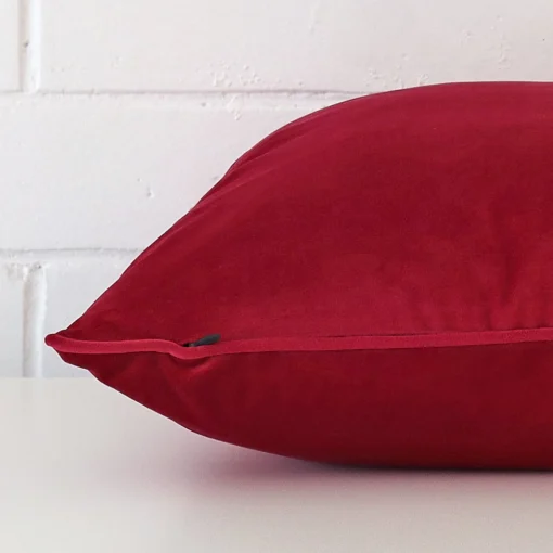 Side angle of fuchsia pink cushion cover that has velvet fabric and a large size.