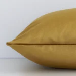 A side view of gold mustard solid-coloured cushion that has velvet fabric and a rectangular shape.