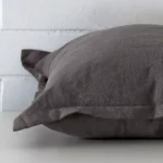 Horizontal edge view of front and back panels of a linen cushion in a large size and with grey colouring.