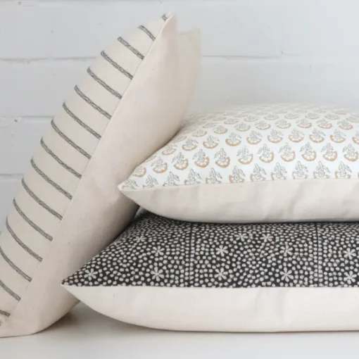 Three handcrafted designer cushions are styled in front of a white background.