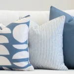 Living room scene with 3 outdoor couch cushions in a blue colour on a sofa.
