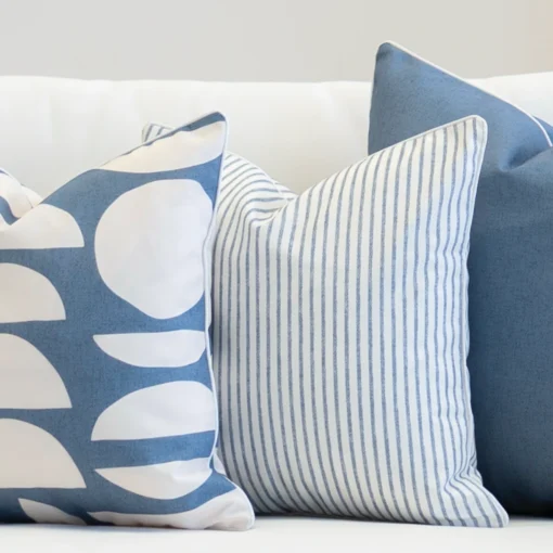 Living room scene with 3 outdoor couch cushions in a blue colour on a sofa.