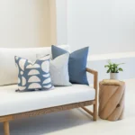Outdoor seating displaying 3 outdoor cushions in a horizon blue colour on a wooden sofa.