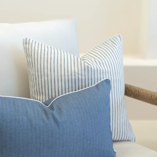 2 horizon blue outdoor cushions are displayed on a white sofa.