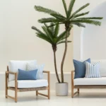 A wooden sofa styled with a set of 3 horizon blue outdoor cushions in a white living room.