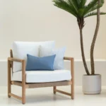 A set of 2 horizon blue outdoor cushions in the corner of a white armchair.