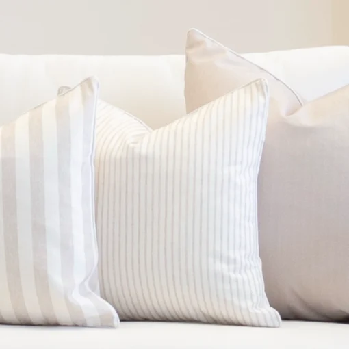 A white couch with a set of 3 outdoor couch cushions in a horizon sage colour.