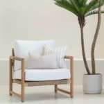 White armchair with 2 horizon sand outdoor cushions arranged neatly on it.