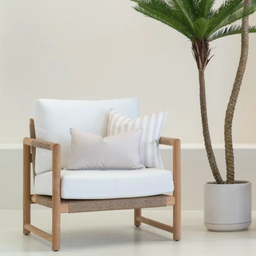 White armchair with 2 horizon sand outdoor cushions arranged neatly on it.