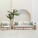 Green cushions styled on outdoor sofa and chair with tropical accents.