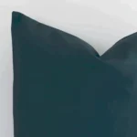 Cropped shot of top left corner of this pine green cushion cover. This viewpoint shows the outdoor fabric and square shape with more precision.