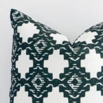 Very close photo of a squared shape geometric cushion. The shot shows the outdoor material and its dark green colour print with more clarity.