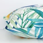 Close side shot of this outdoor cushion cover. The viewpoint shows how the square design and decorative finish meet along its edge.