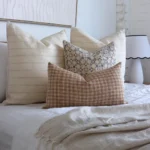 A bright bedroom showcasing 4 elegant designer from the Lennox bed cushions set.