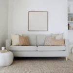A beautiful combination of 5 designer cushions positioned on light grey sofa.