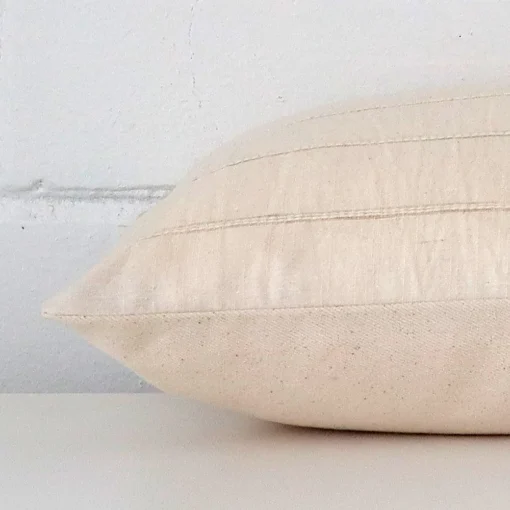 Horizontal edge view of front and back panels of a striped designer cushion in a rectangle size.