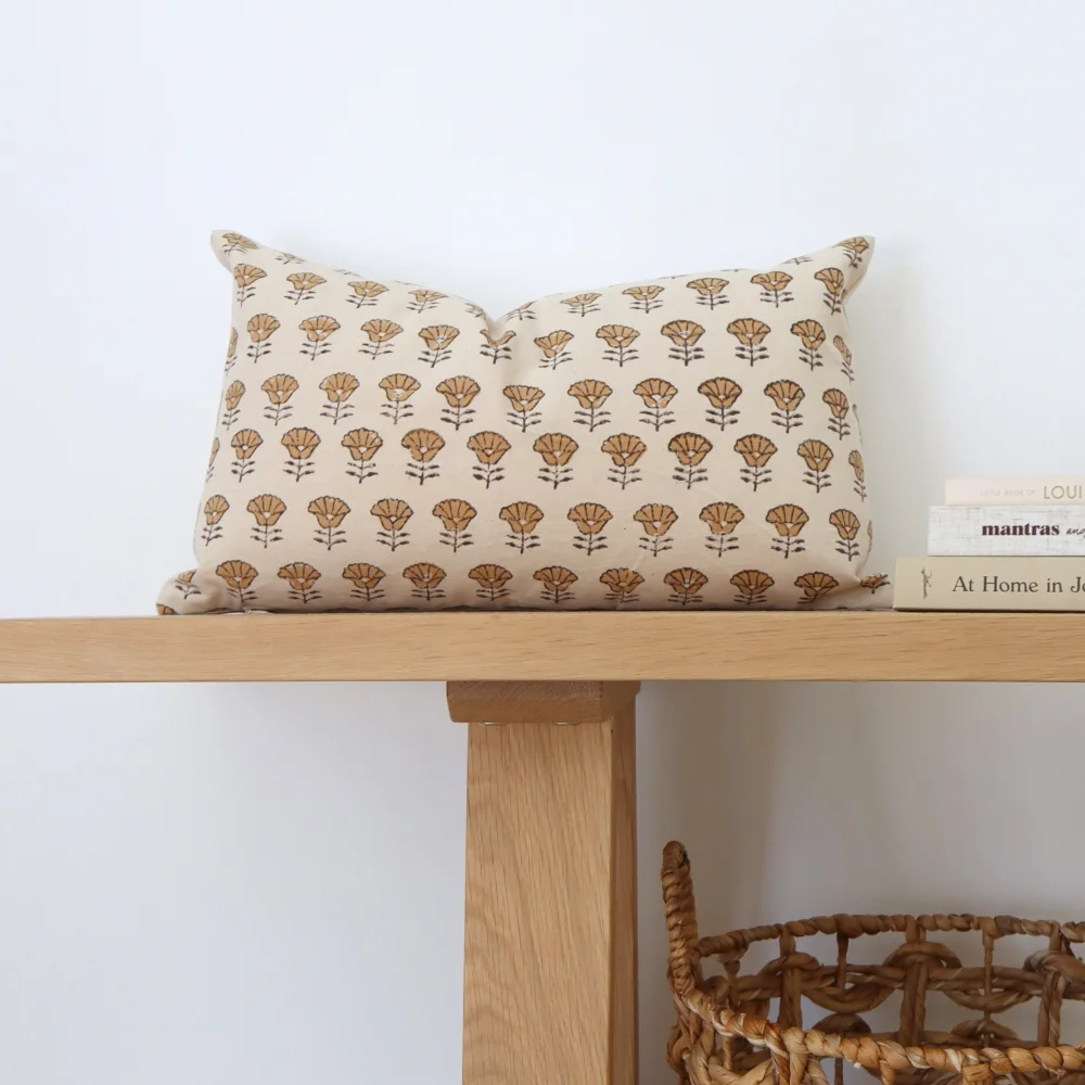 A light coloured wooden bench with a retro cushion on its top.