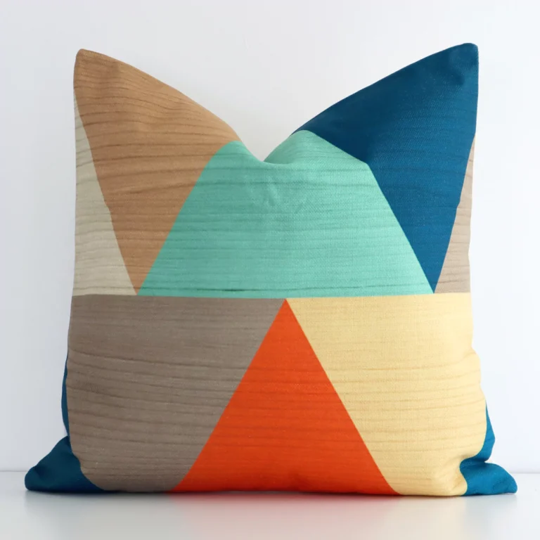 Square geometric cushion cover in colourful colour sitting upright in front of a white wall. It has been made from a quality linen material.