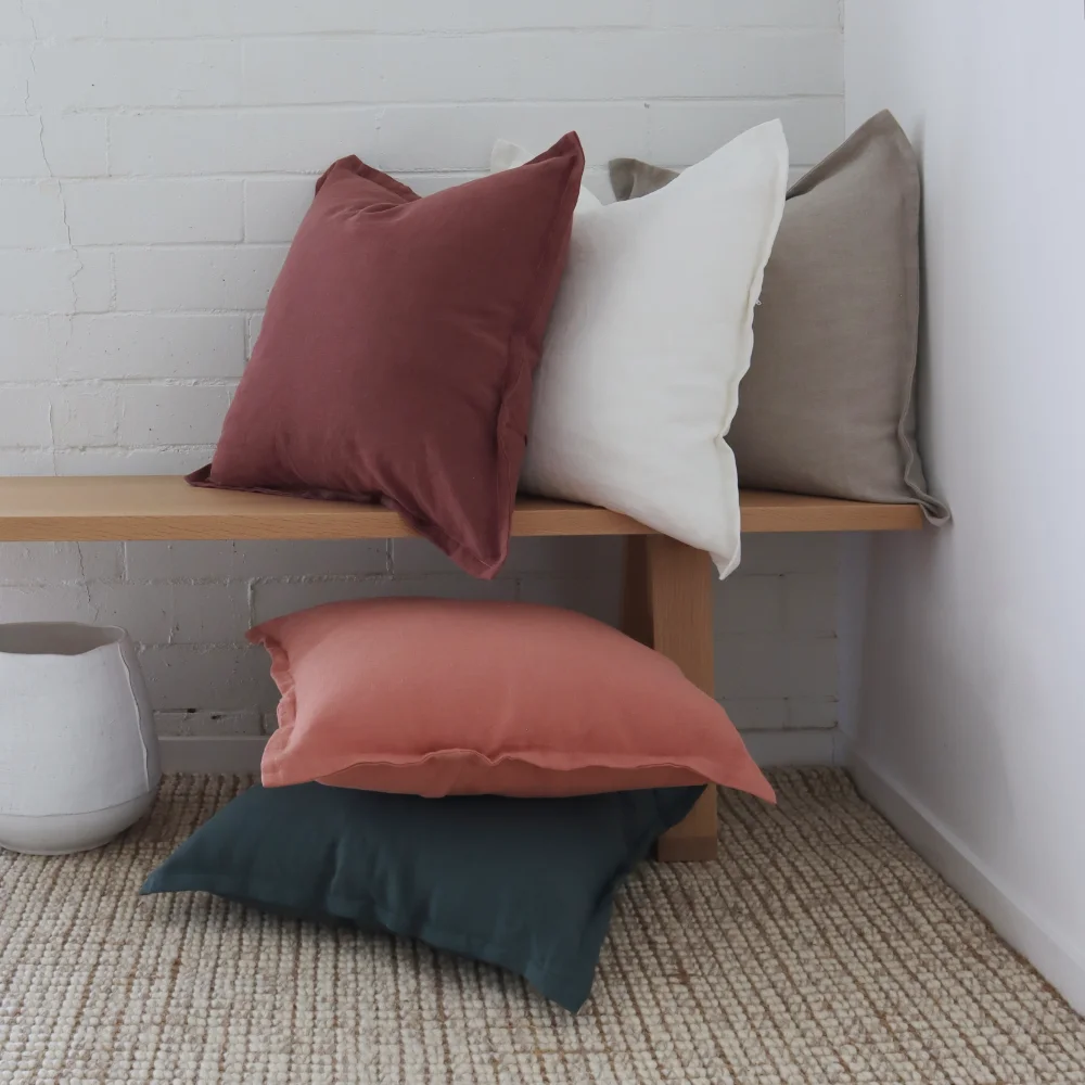 A long bench is shown with decorative cushions laid on and around it.