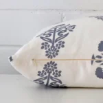 Side image of a linen rectangle cushion cover. The light blue colour design is visible from the side showing the attachment of the panels.