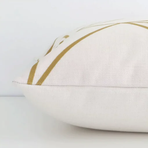 A square cushion with a gold mustard print cover laying flat. This viewpoint highlights the geometric style and linen fabric.