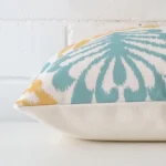 A square linen cushion positioned flat to show its seams. The patterned design is visible as is the seam between the panels.