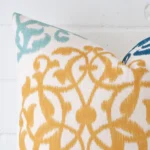 A very close image of the corner of a patterned linen cushion in a square shape.