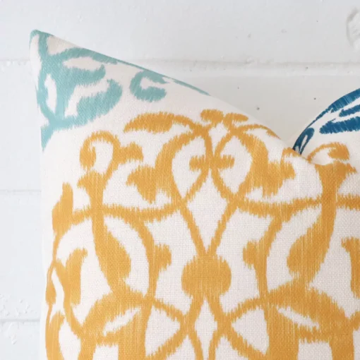 A very close image of the corner of a patterned linen cushion in a square shape.