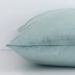 Side angle shot of velvet square cushion cover. The mint hue and solid colour style are shown along its seams.
