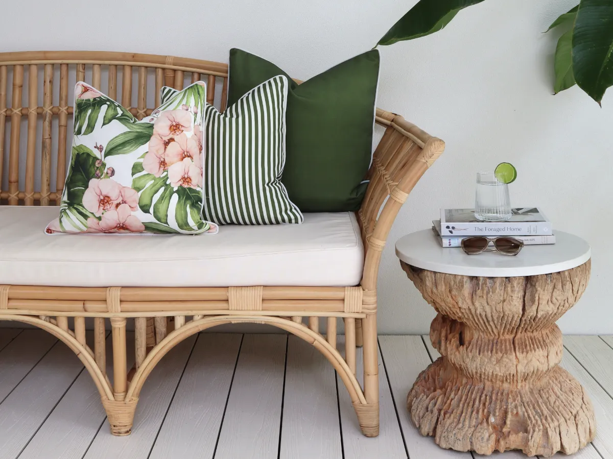 A neat arrangement of outdoor cushions in a set of three with a solid and a stripe and a feature design in front.
