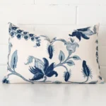 Cushion positioned in front of a brick wall. It has rectangle dimensions and is made from a linen material.
