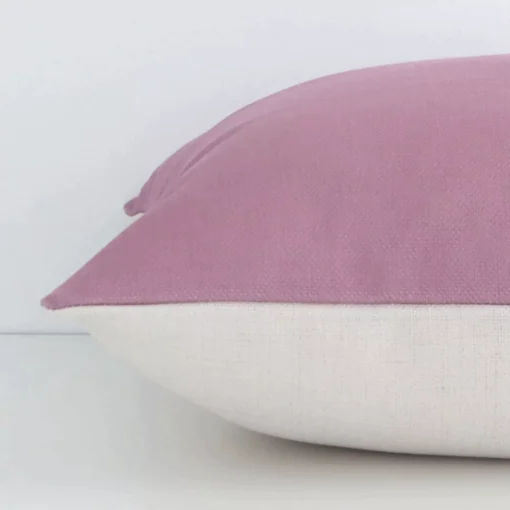 Horizontal edge of solid colour square cushion cover is shown. The linen fabric and blush tone can be seen from this side view.