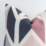 A linen square cushion’s corner has been enlarged in this shot. The detail of the geometric design and colourful colour are visible.