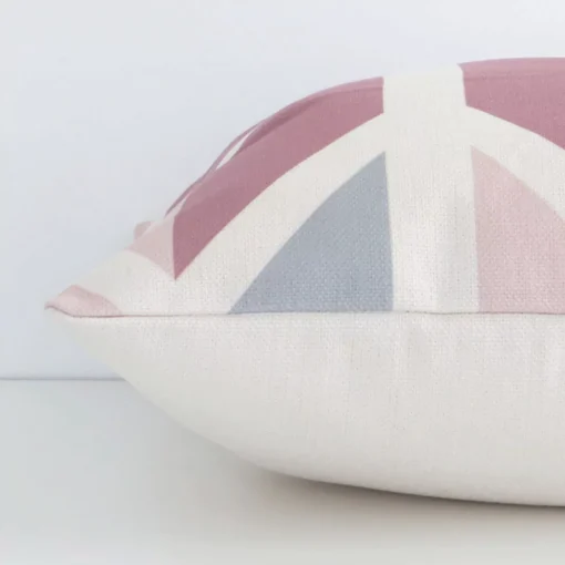A patterned colourful cushion cover is laid flat. This angle shows the side of the linen fabric and its square shape.