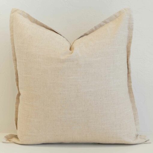 Oatmeal linen cushion with button closure detail and natural woven texture.