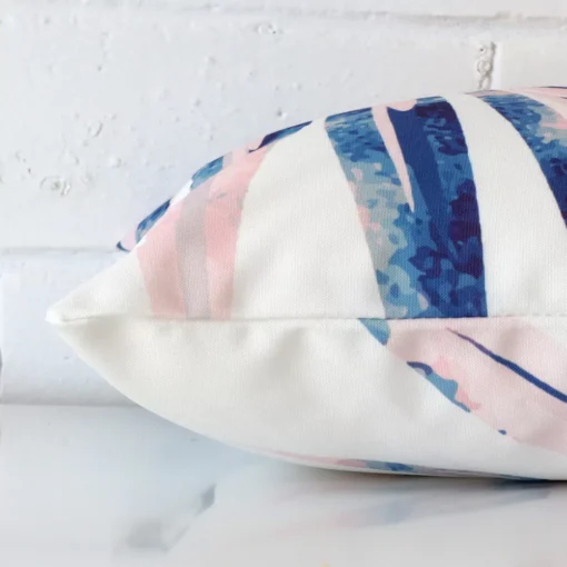 A pink cushion positioned on its back panel. The shot shows a lateral view of the outdoor fabric and its rectangle size.