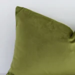 Magnified view of this velvet olive cushion cover’s corner showing a solid coloured design and its rectangle shape.