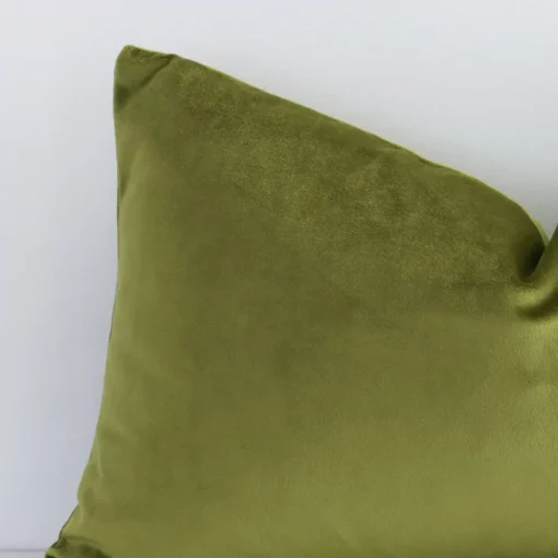 Magnified view of this velvet olive cushion cover’s corner showing a solid coloured design and its rectangle shape.