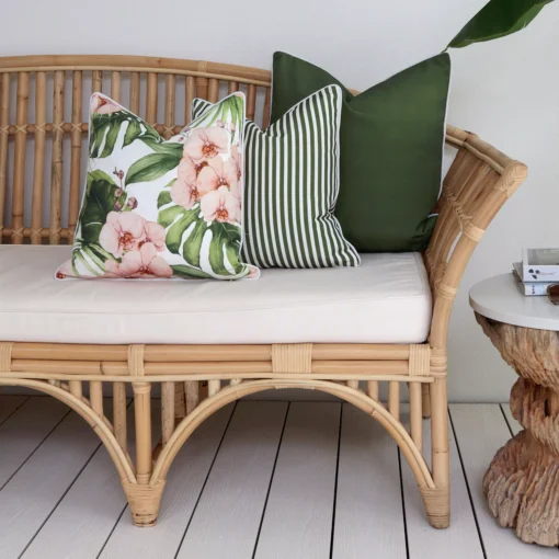 A set of 3 olive outdoor couch cushions including one with a floral design.
