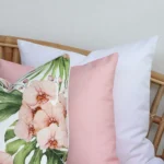 A close-up image of 3 pink outdoor couch cushions provides a thorough view of the colour hue and style.