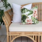 Outdoor seating adorned with 2 pink couch cushions infusing a tropical vibe into your outdoor oasis.