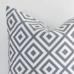 Focused view of a square grey geometric printed cushion cover. The shot shows details of its outdoor material.