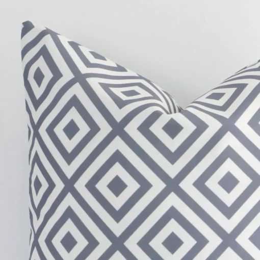Focused view of a square grey geometric printed cushion cover. The shot shows details of its outdoor material.