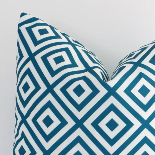 A detailed shot of this teal geometric cushion cover that has outdoor fabric and has a square size.