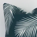 Close up of an outdoor square cushion in green. The quality of its palm design is shown in fine detail.